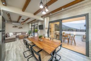 a dining room and living room with a table and chairs at Villa La Bianca in Marketáta