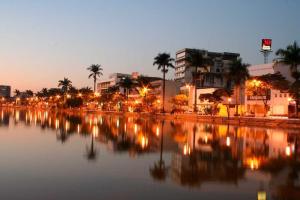 a large body of water with buildings and palm trees at Kitnet Apart-Hotel 4 in Sete Lagoas