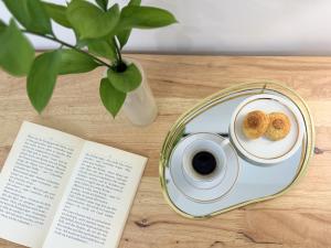 a plate with a cup of coffee and a book at Dimora dei Mercanti Suites - New Premium Rooms in Turin