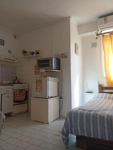 a kitchen with a stove and a bed in a room at El rincón de boedo in Buenos Aires
