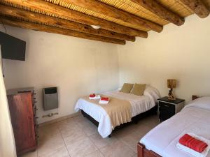 a bedroom with two beds and a tv in it at Usina Elias in Tilcara