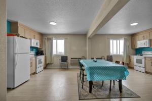 a kitchen with a table with a blue table cloth at Wilshireinn Hotel in Claresholm