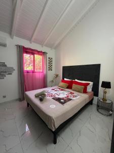 a bedroom with a large bed with a pink door at Villa zion in Deshaies