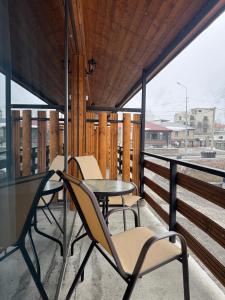 a patio with chairs and a table on a balcony at Tetri Jikhvi in Kazbegi