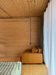 a couch in a room with a wooden wall at Tetri Jikhvi in Kazbegi