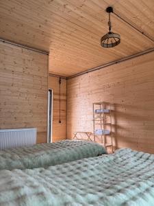 a bedroom with a bed with a wooden wall at Tetri Jikhvi in Kazbegi