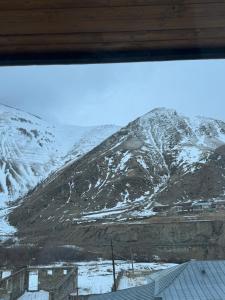 a view of a snow covered mountain from a window at Tetri Jikhvi in Kazbegi +64 photos