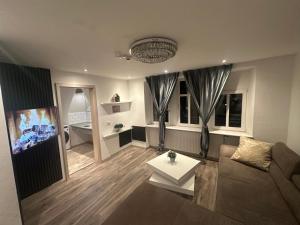 a living room with a couch and a table at Kurvilla Apartments in Landstuhl +5 photos