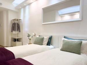 two beds in a bedroom with a mirror and a window at Dimora dei Mercanti Suites - New Premium Rooms in Turin