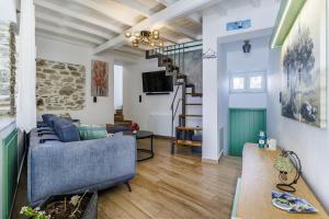 a living room with a blue couch and a staircase at Larimis House in Loutraki