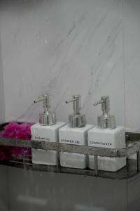 a group of three soap dispensers on a shelf at Sun Beach Dhigurah in Dhigurah