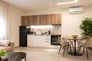 a kitchen and living room with a table and chairs at Nouvelles Roses 1 in Nea Roda +7 photos