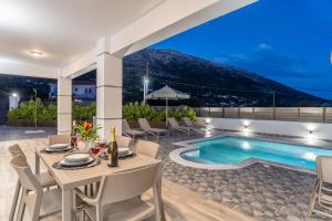 a patio with a table and chairs and a swimming pool at Villa La Bianca in Marketáta