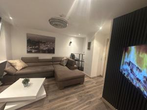 a living room with a couch and a flat screen tv at Kurvilla Apartments in Landstuhl