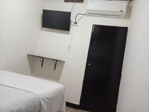 ein Zimmer mit einem Bett und einem Fernseher an der Wand in der Unterkunft Hotel La Séptima in Neiva