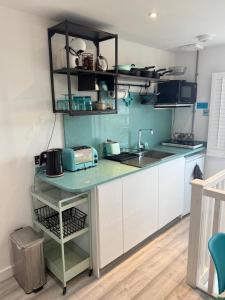 a kitchen with white cabinets and a counter top at Studio Tavros in Bristol