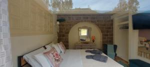 ein Schlafzimmer mit einem Bett in einer Ziegelwand in der Unterkunft Tsaner Apartment and Rooms in Matala