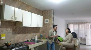 a man and a woman standing in a kitchen at Mom's House Floralia in Cali