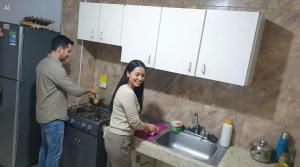 a man and woman standing in a kitchen preparing food at Mom's House Floralia in Cali +18 photos