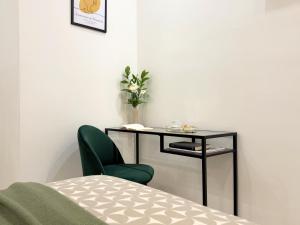 a bedroom with a table and a green chair at Dimora dei Mercanti Suites - New Premium Rooms in Turin +40 photos