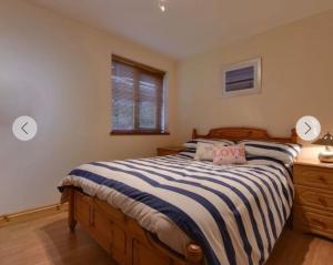 a bedroom with a bed with a striped comforter at Eureka Whitsands in Antony