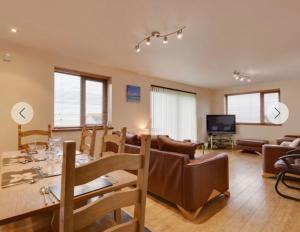 a living room with a table and a dining room at Eureka Whitsands in Antony