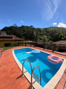 a swimming pool with two inflatables in a house at Refúgio Carangola in Petrópolis