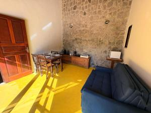 a living room with a blue couch and a table at Refúgio Carangola in Petrópolis