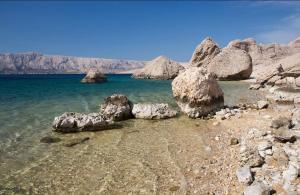 a group of large rocks in the water at Apartments-LUCKY STAR,NOVALJA -PAG in Novalja