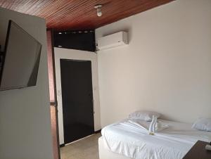 ein Schlafzimmer mit einem Bett und einer Tür mit einem Ventilator in der Unterkunft Hotel La Séptima in Neiva