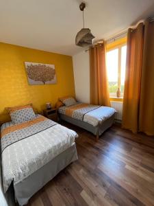 a bedroom with two beds and a window at Chez F & G terrasse privée dans jardin - parking in Sélestat