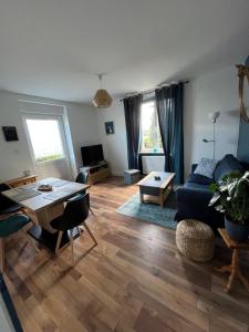a living room with a blue couch and a table at Chez F & G terrasse privée dans jardin - parking in Sélestat