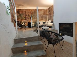 ein Wohnzimmer mit Treppe und Stühlen und einem Kamin in der Unterkunft Hotel Raimblanc in Villargordo del Cabriel