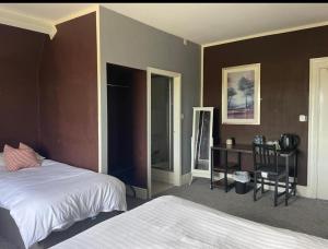 a bedroom with two beds and a desk with a chair at THE YoRK in Morecambe