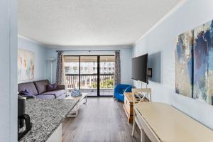 a living room with a couch and a table at Heated Pool Beach View Beachside Haven Balcony in Galveston