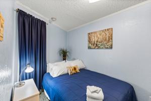 a bedroom with a blue bed and a painting on the wall at Heated Pool Beach View Beachside Haven Balcony in Galveston +34 photos