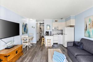 a living room and kitchen with a couch and a table at Heated Pool Beach View Beachside Haven Balcony in Galveston