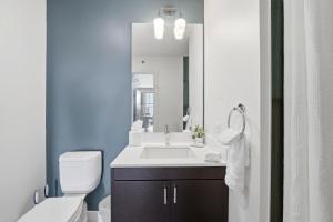 a bathroom with a sink and a toilet and a mirror at The Plymouth Chicago in Chicago