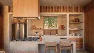 a kitchen with a stove and a counter with chairs at Salara Boutique Hotel & Villas Todos Santos in Todos Santos +78 photos