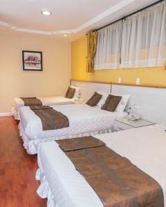 a group of four beds in a room at Kuna Hotel in Cuenca +70 photos