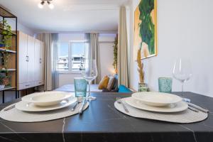 a dining room table with plates and glasses on it at ILIRIA Apartment in Durrës +24 photos