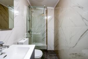 a bathroom with a shower and a sink and a toilet at MARTINI APARTMENTs MAISONETTE in Nikiti +10 photos