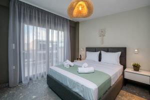 a bedroom with a large bed with towels on it at MARTINI APARTMENTs MAISONETTE in Nikiti
