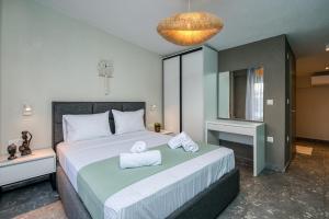 a bedroom with a large bed with towels on it at MARTINI APARTMENTs MAISONETTE in Nikiti