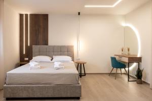 a bedroom with a bed and a desk and a chair at Nouvelles Roses 1 in Nea Roda