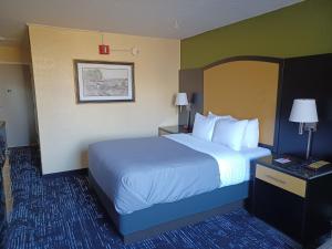 a hotel room with a large bed with white pillows at Quality Inn Conference Center Logansport in Logansport +26 photos