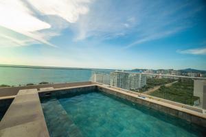 a swimming pool on the roof of a building at Refugio Del Mar Bello Horizonte Playa Dormida in Santa Marta