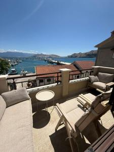 a balcony with a couch and chairs and a table at Family Apartman Baška in Baška