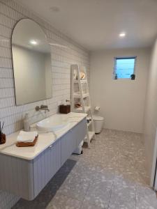 a bathroom with a sink and a mirror and a toilet at Seaclusion at Byron in Byron Bay