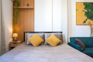 a bedroom with a bed with yellow pillows and a blue couch at ILIRIA Apartment in Durrës